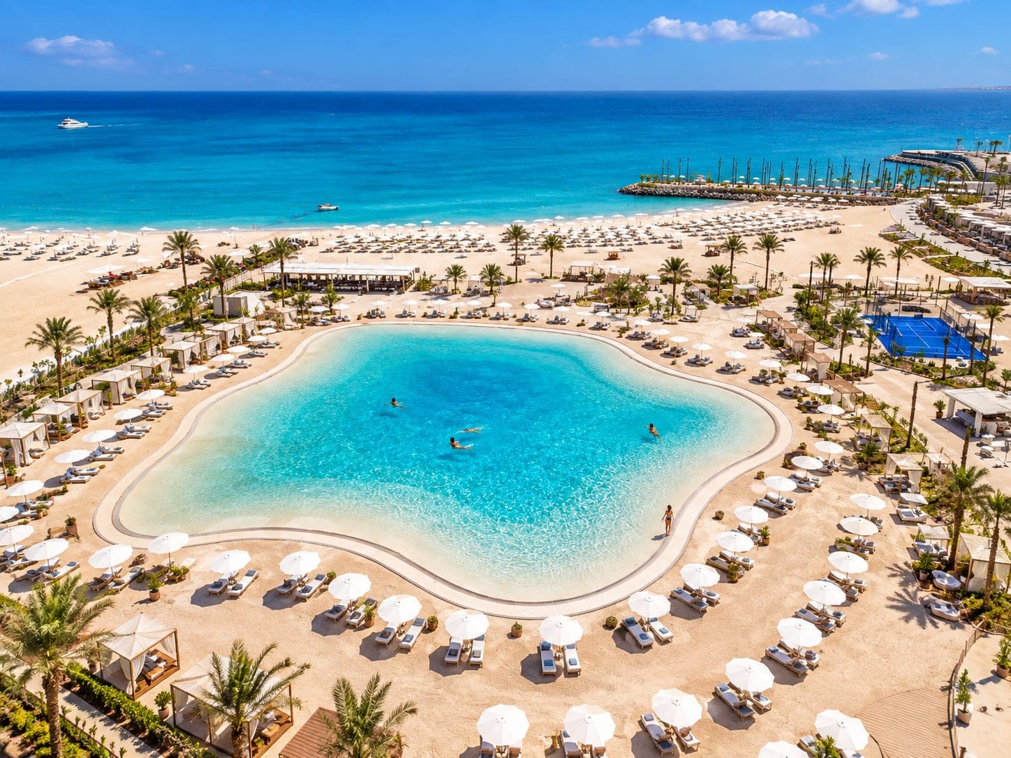 Aerial view of a luxury North Coast resort featuring a turquoise lagoon, sandy beach, and Mediterranean Sea.